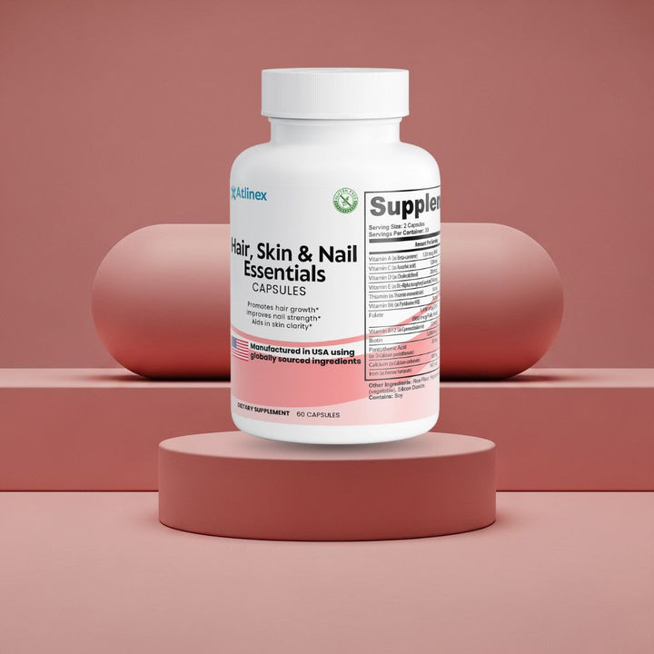 Supplement bottle labeled Atlinex 'Hair, Skin & Nail Essentials' on a pink platform with a pink background